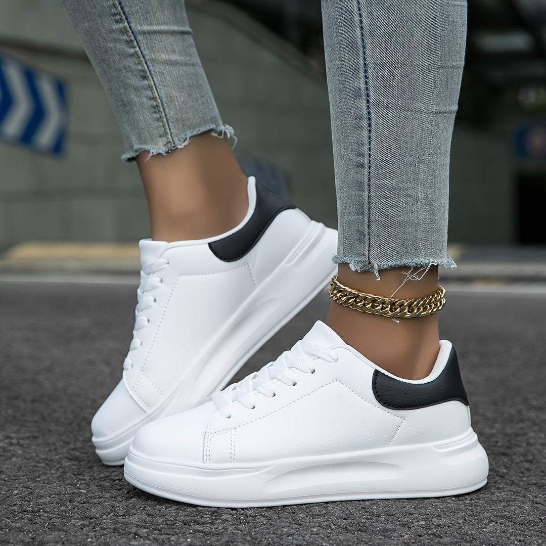 Chic white low-top women's sneakers, perfect for versatile everyday style.
