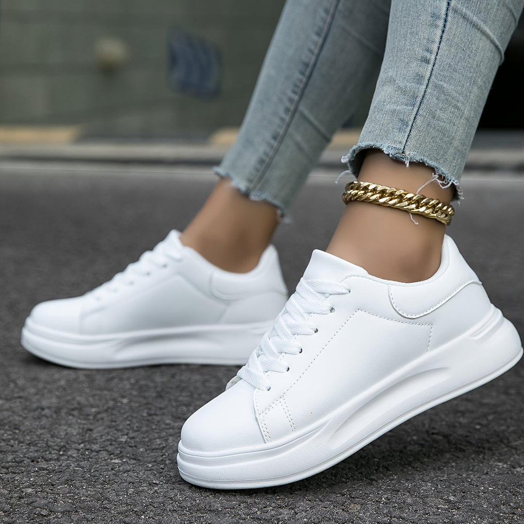 Women's clean white low-top sneakers, offering comfort & chic versatility for everyday style.