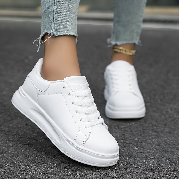 Crisp white low-top women's sneakers, a comfortable and stylish choice for casual wear.
