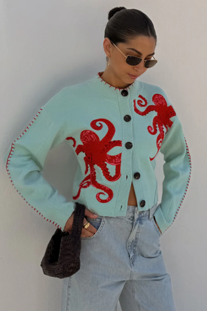 Elegant women's blue long-sleeve sweater showcasing a detailed nautical octopus graphic. Coastal fashion.