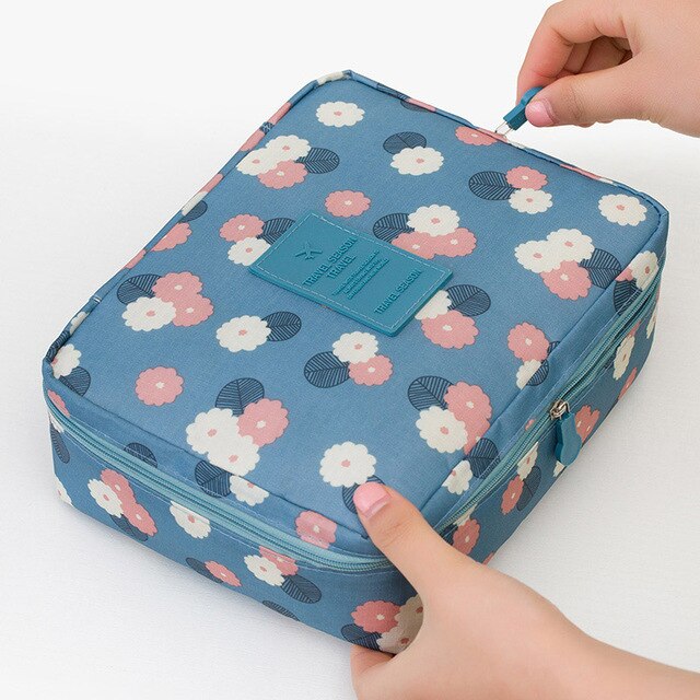 Waterproof makeup organizer for women, dark blue flowers, compact travel toiletry bag, beauty essentials.