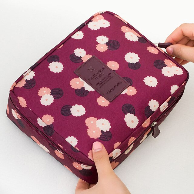 Portable dark blue floral waterproof cosmetic travel case for women, compact for makeup and accessories.