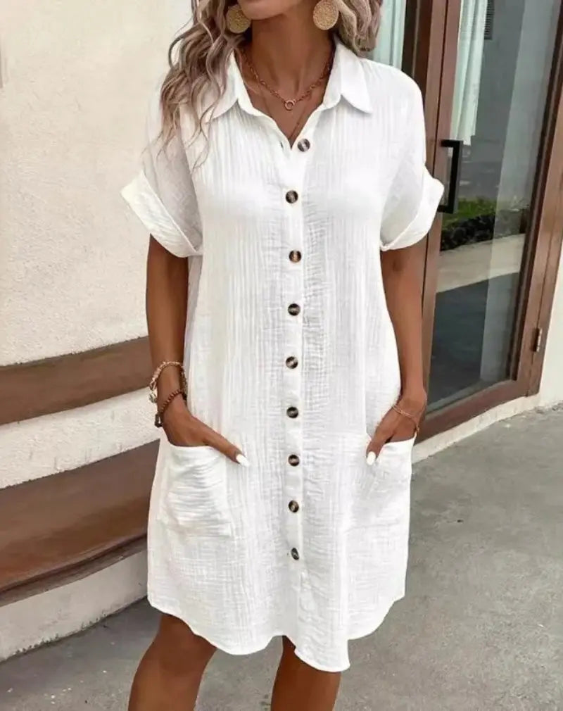 Women's short-sleeve shirtdress with patch pockets. Button-down, collared, and relaxed fit for casual wear.