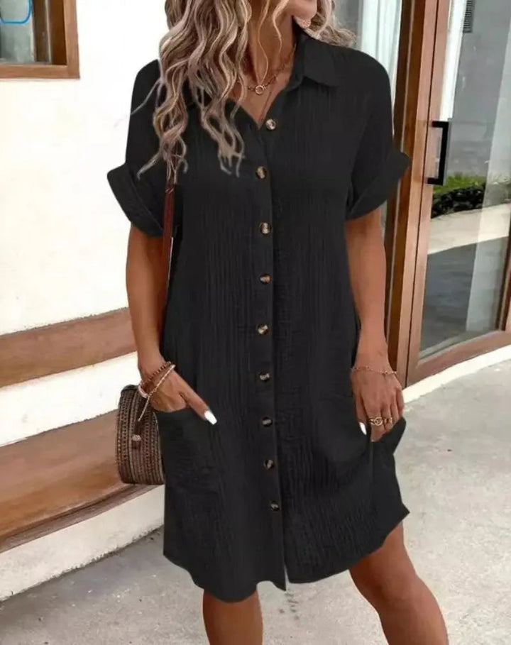 Relaxed fit short-sleeve shirt dress for women, featuring a button-down front, collar, and practical patch pockets.