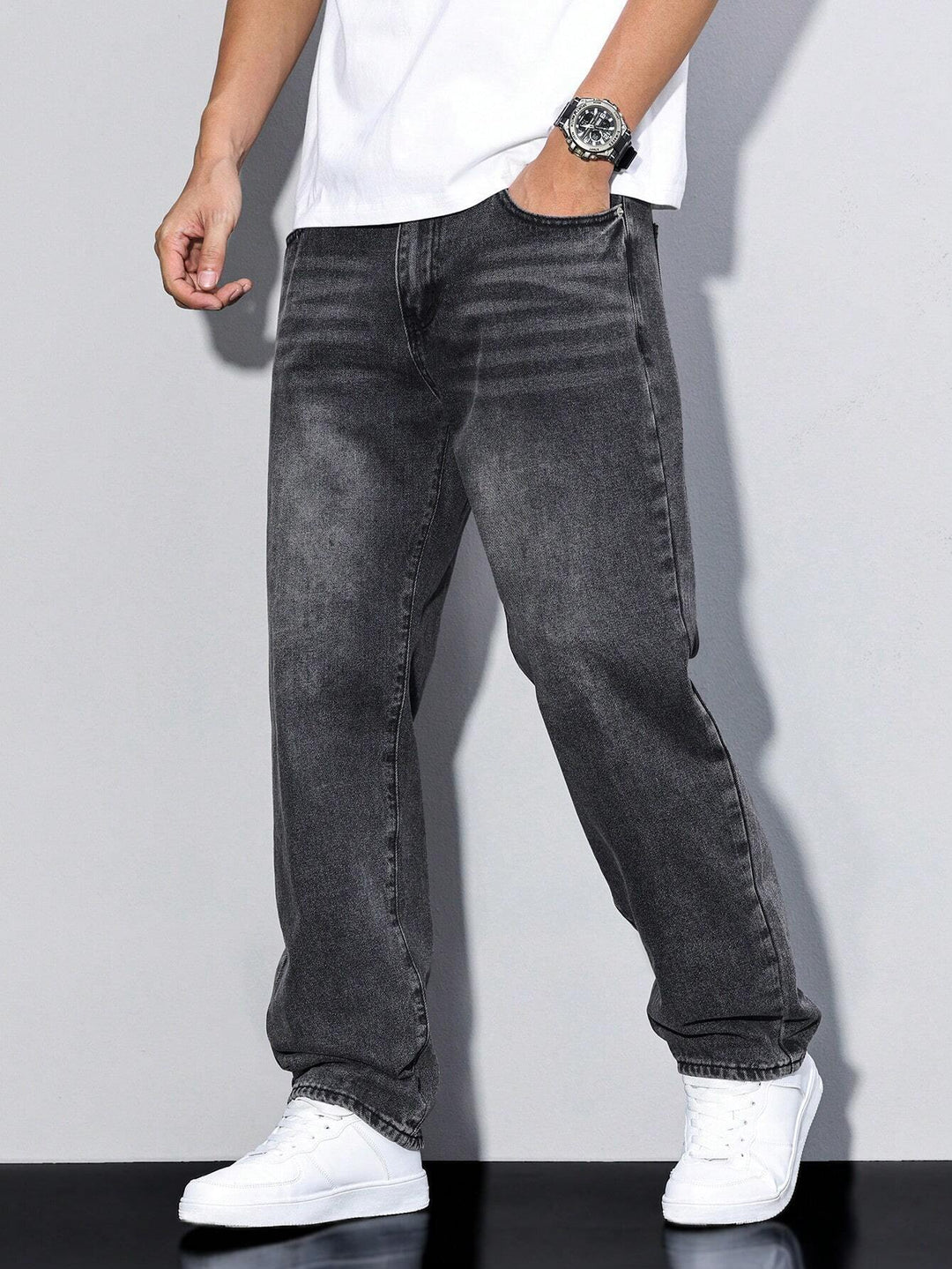 Detail shot of the waistband and button closure on men's washed straight leg jeans.