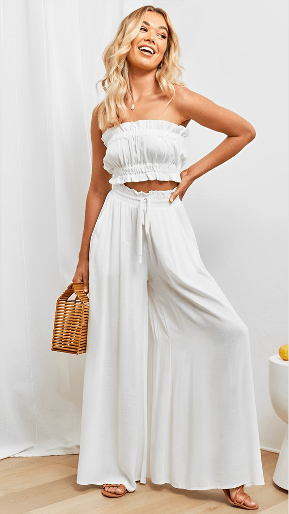 Model in flowing Lily wide-leg trousers, styled casually for spring/summer comfort.