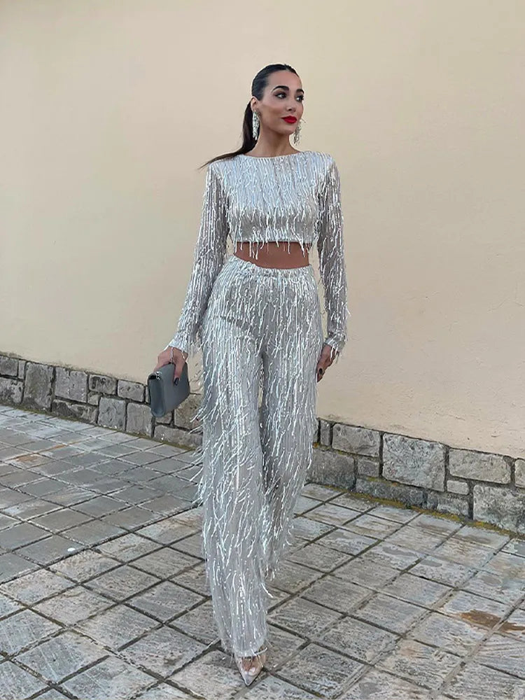 Full-length view of a women's glamorous sequin top and high-waist trousers evening set.