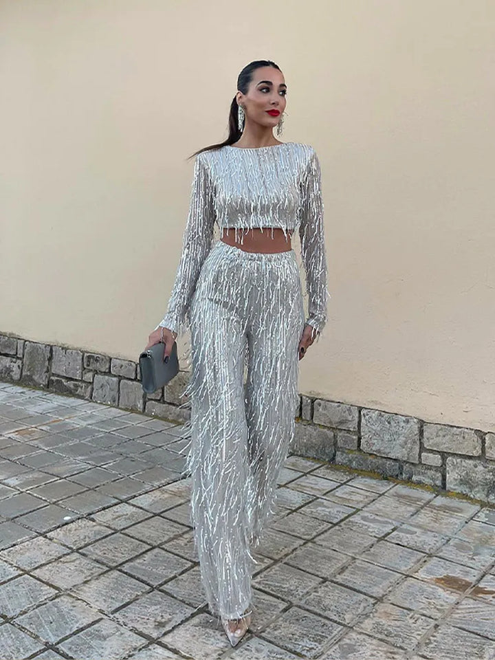 Full-length view of a women's glamorous sequin top and high-waist trousers evening set.