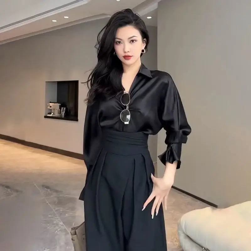 Women's high-waisted wide-leg pants with crossed waistband, versatile for elegant workwear or casual spring/summer outfits.