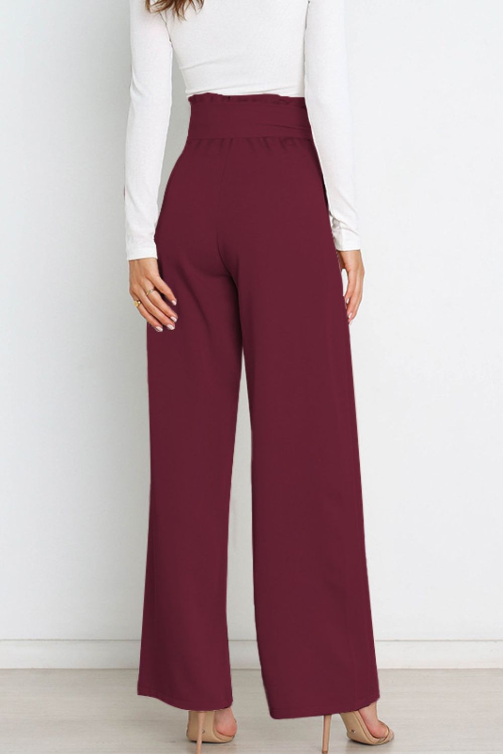 Office wear women's paperbag trousers, high waist, wide leg, and a sophisticated bow.
