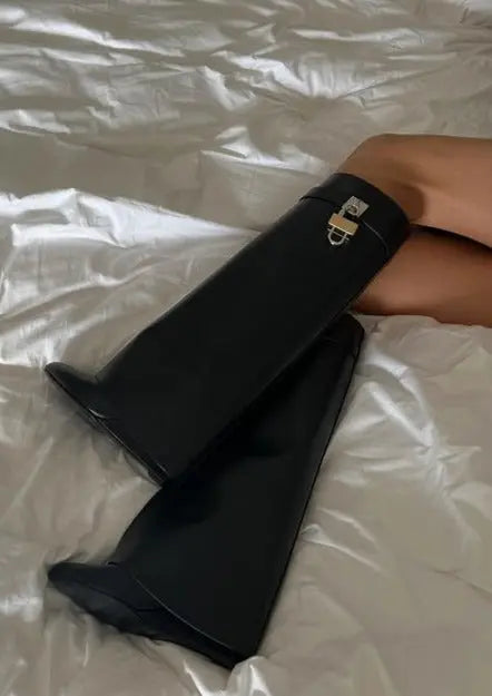 Stylish women's knee-high boots with a glossy finish and a sculptural wedge heel design.