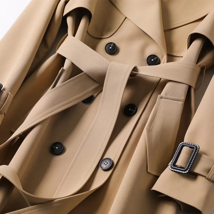 Durable women's classic trench coat with belt, offering weather resistance and timeless appeal.