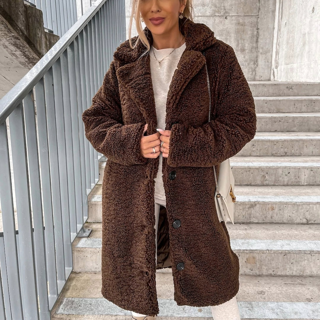 Stylish women's long winter coat in plush material, offering warmth and a trendy oversized silhouette.