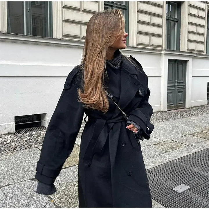 Versatile long black women's trench coat, double-breasted with a cinched belted waist. Perfect for spring & fall outerwear.