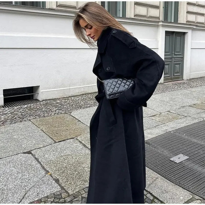 Stylish women's black double-breasted trench coat. Chic belted waist details elevate this classic fall fashion.