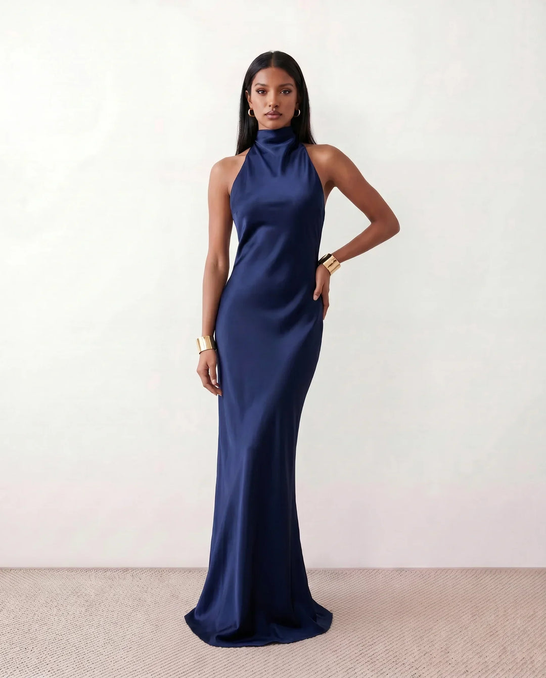 Stylish women's halter neck maxi dress with a flowing skirt, suitable for elegant parties or relaxing vacation wear.
