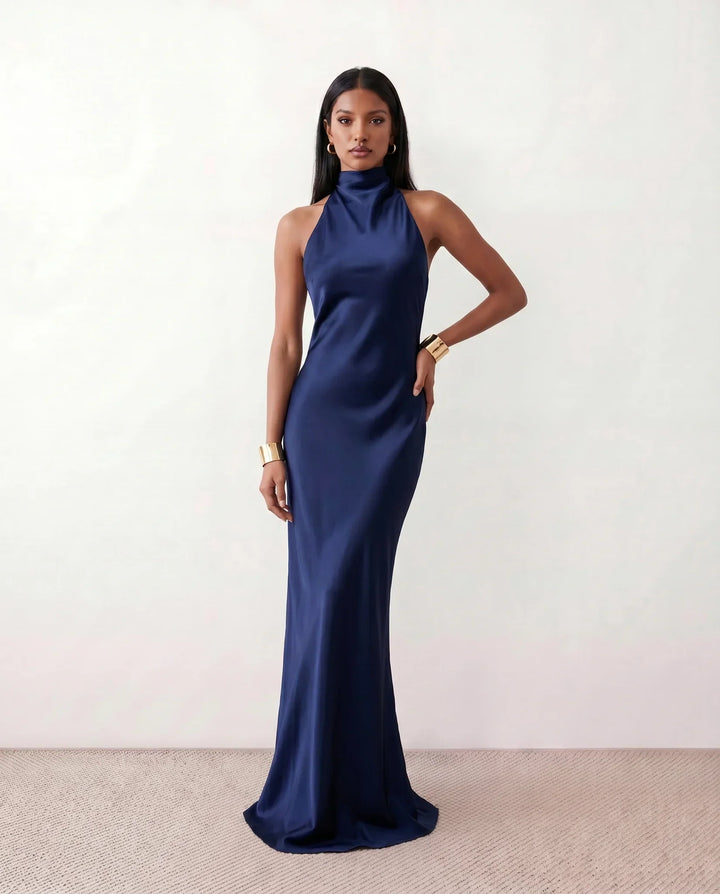 Stylish women's halter neck maxi dress with a flowing skirt, suitable for elegant parties or relaxing vacation wear.