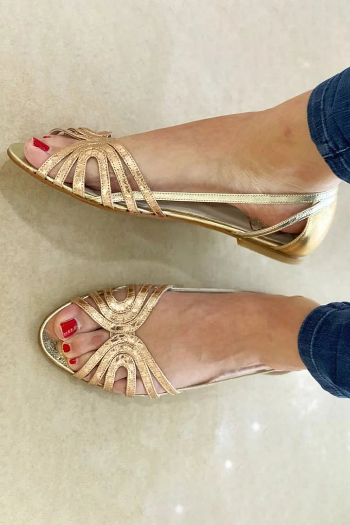 Golden women's flat sandals, perfect for summer comfort & elegant holiday style. Slip-on, open-toe design.