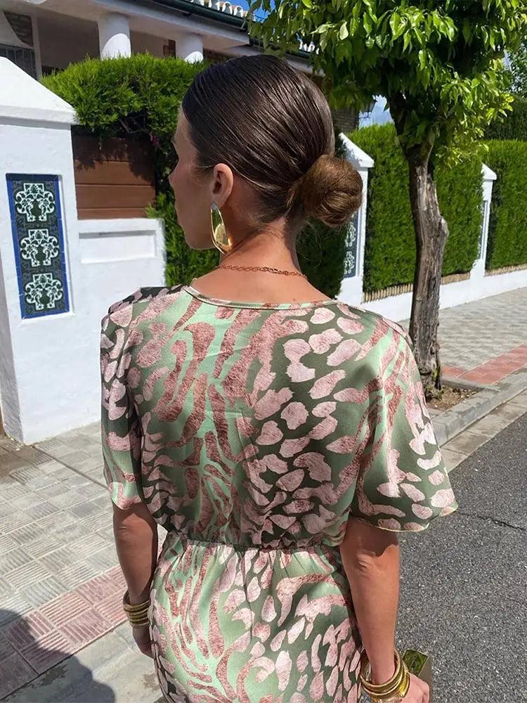 Close-up of a women's twist-front printed midi dress, showcasing the V-neck and elegant occasion wear fabric.