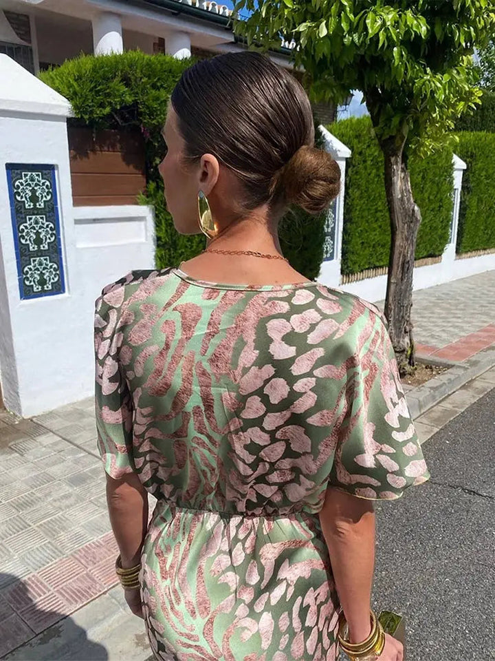 Close-up of a women's twist-front printed midi dress, showcasing the V-neck and elegant occasion wear fabric.
