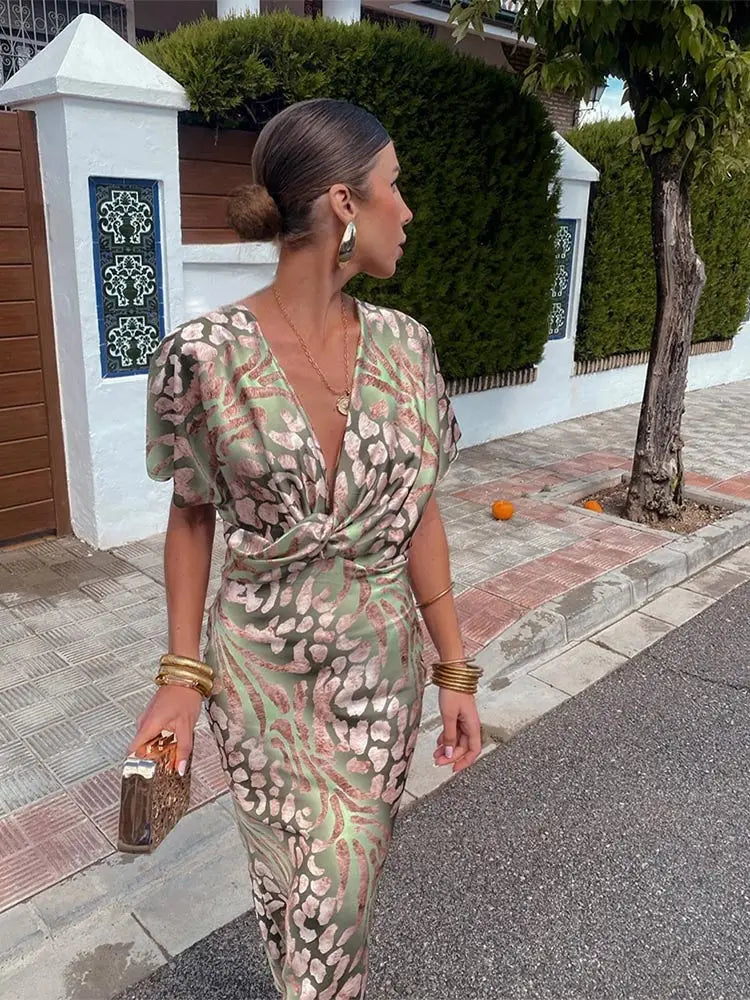 Chic summer wedding guest midi dress with an eye-catching print, twist-front detail, and comfortable fluid design.