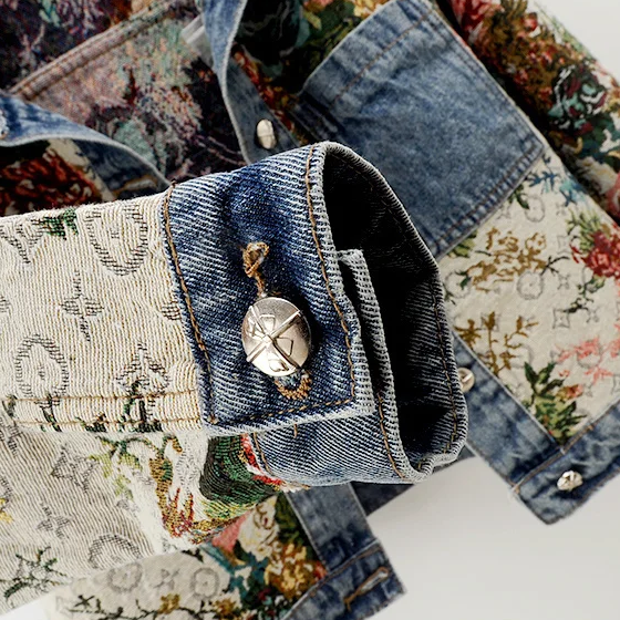 Statement women's denim jacket, featuring intricate hand-painted floral art. Ideal unique fashion piece.