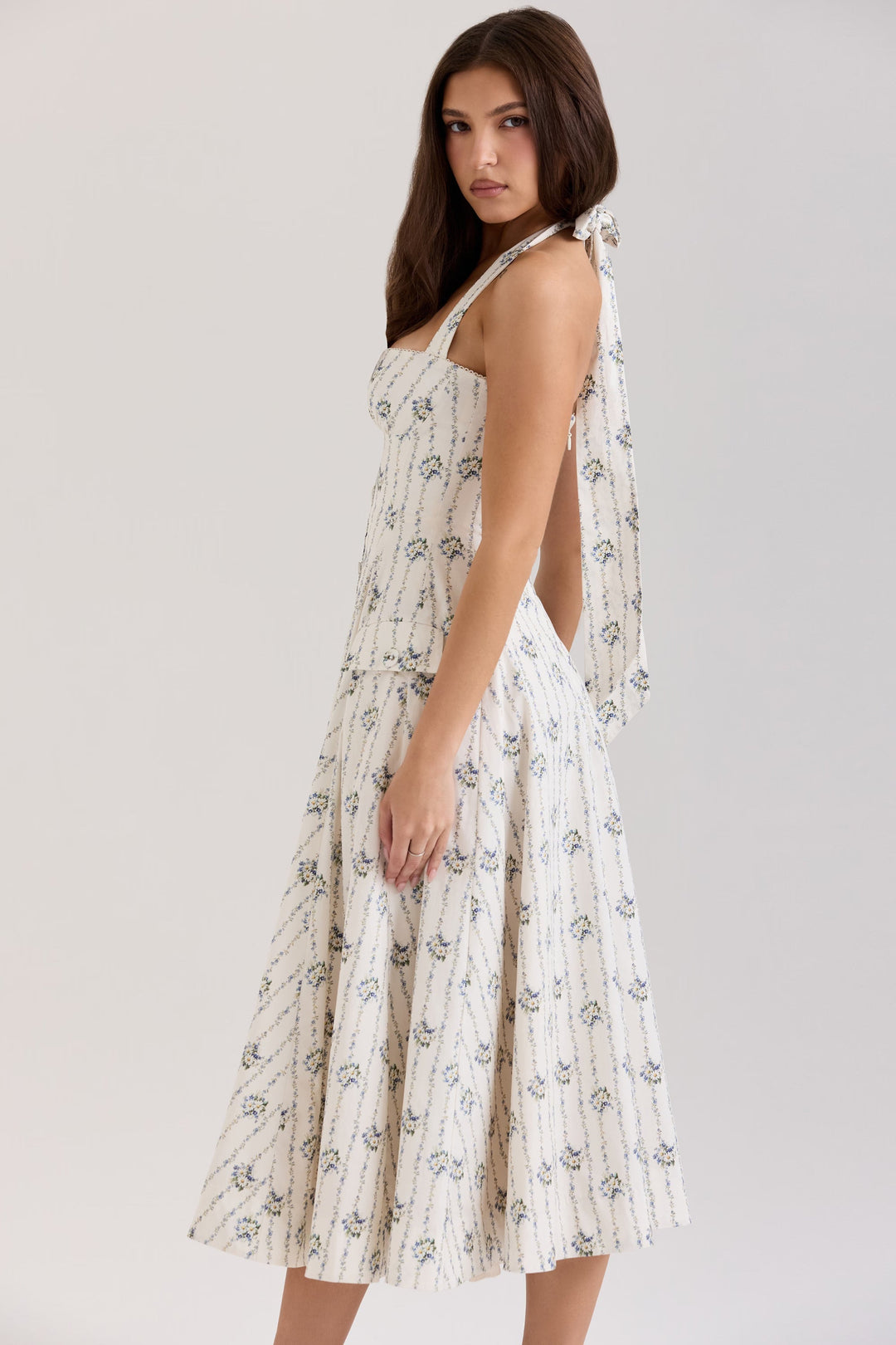 Elegant women's daisy print halter neck midi dress, flattering A-line silhouette, ideal for summer parties.