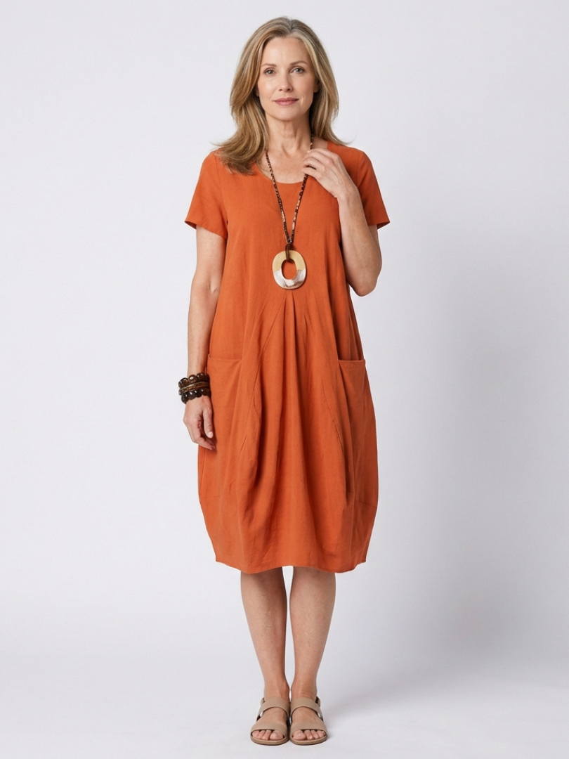 Women's short sleeve pleated knee-length dress for effortless everyday style. Comfortable relaxed fit with side pockets.