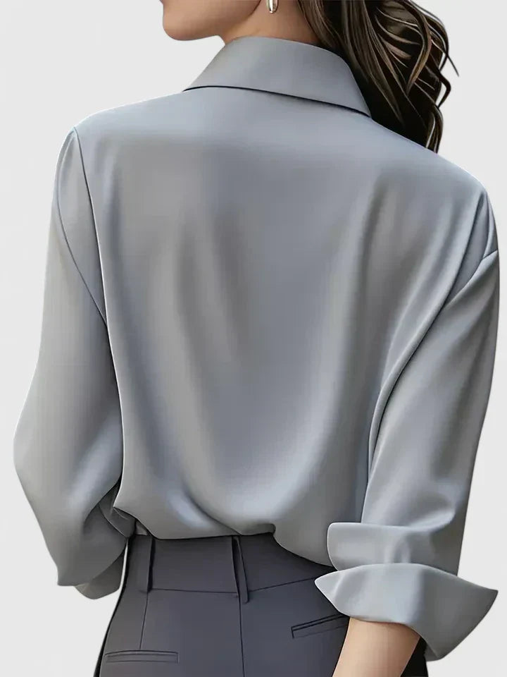 Simple yet elegant women's button-down blouse. A classic long sleeve top with a chic curved hem design.