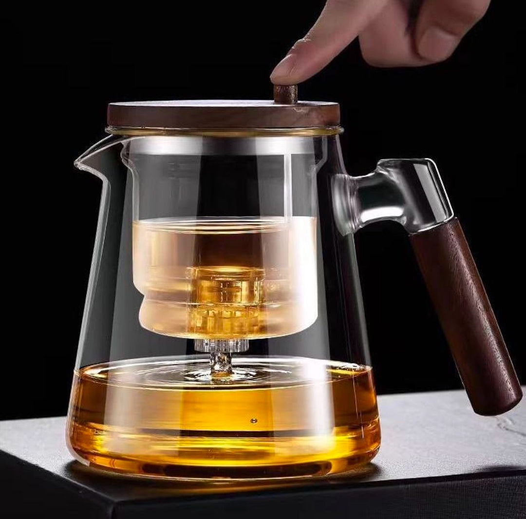 Elegant borosilicate glass teapot with heat-resistant design & built-in infuser for loose leaf tea. Wooden handle.