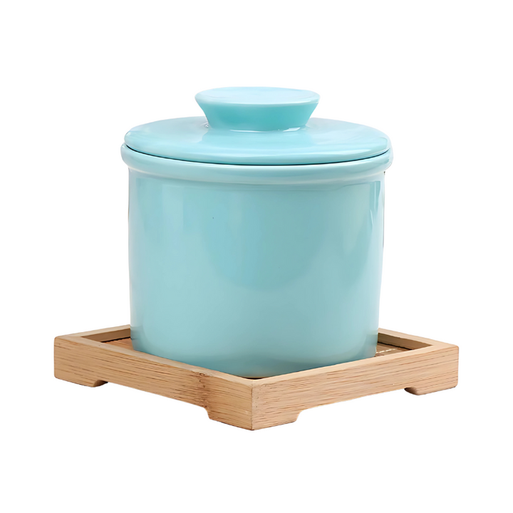 "Elegant ceramic butter keeper with water-sealed system in sleek black, light blue, and white, perfect for kitchen décor."