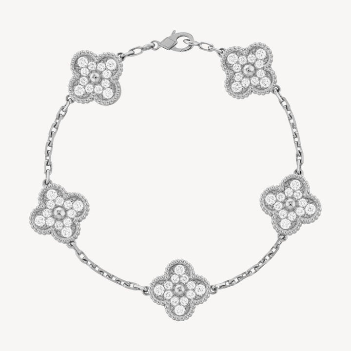 Elegant clover charm bracelet with polished black agate inlays and a gold and silver-tone chain for sophisticated style.