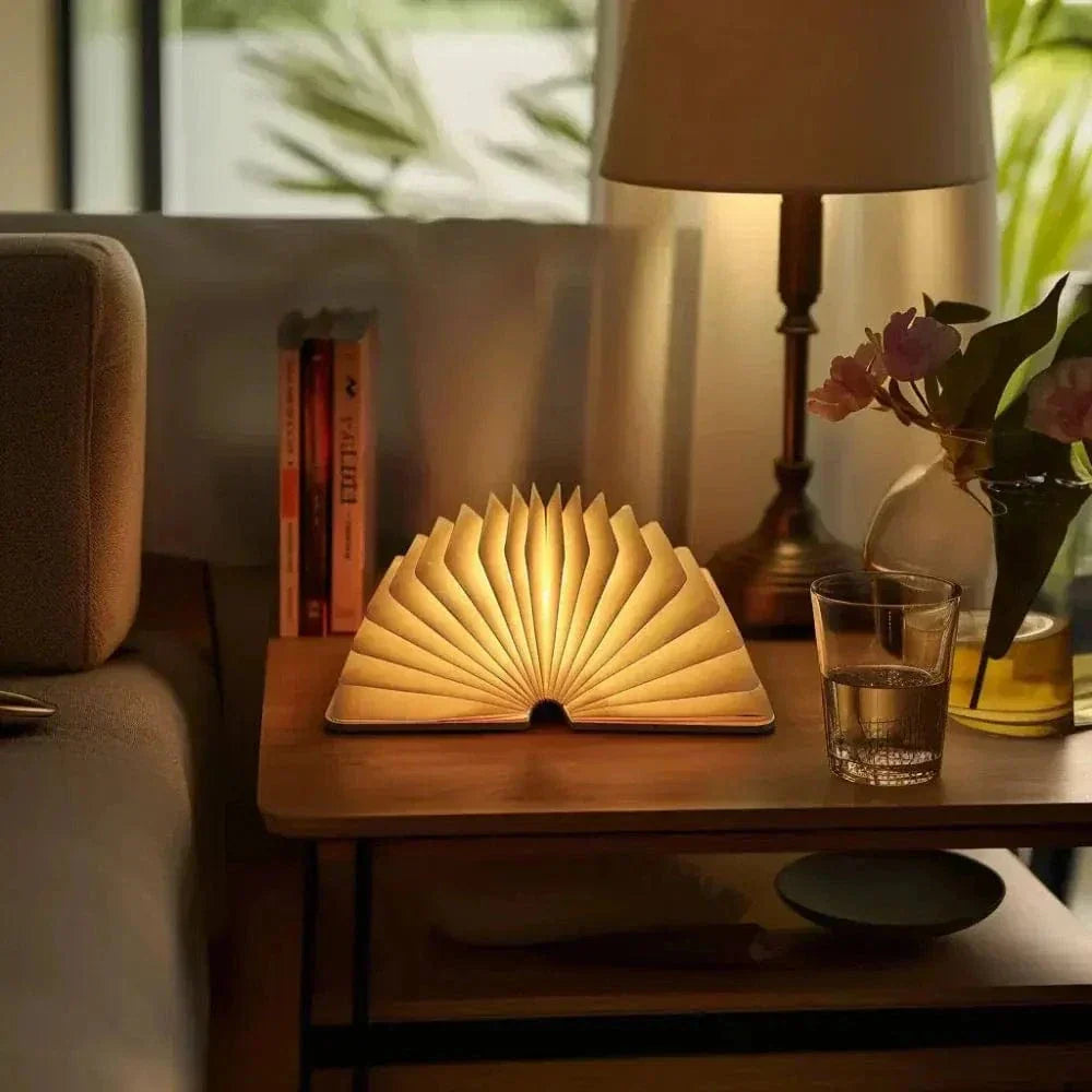 "Elegant foldable LED book lamp, warm white light, 360-degree design, portable for home or travel, wood and paper material."