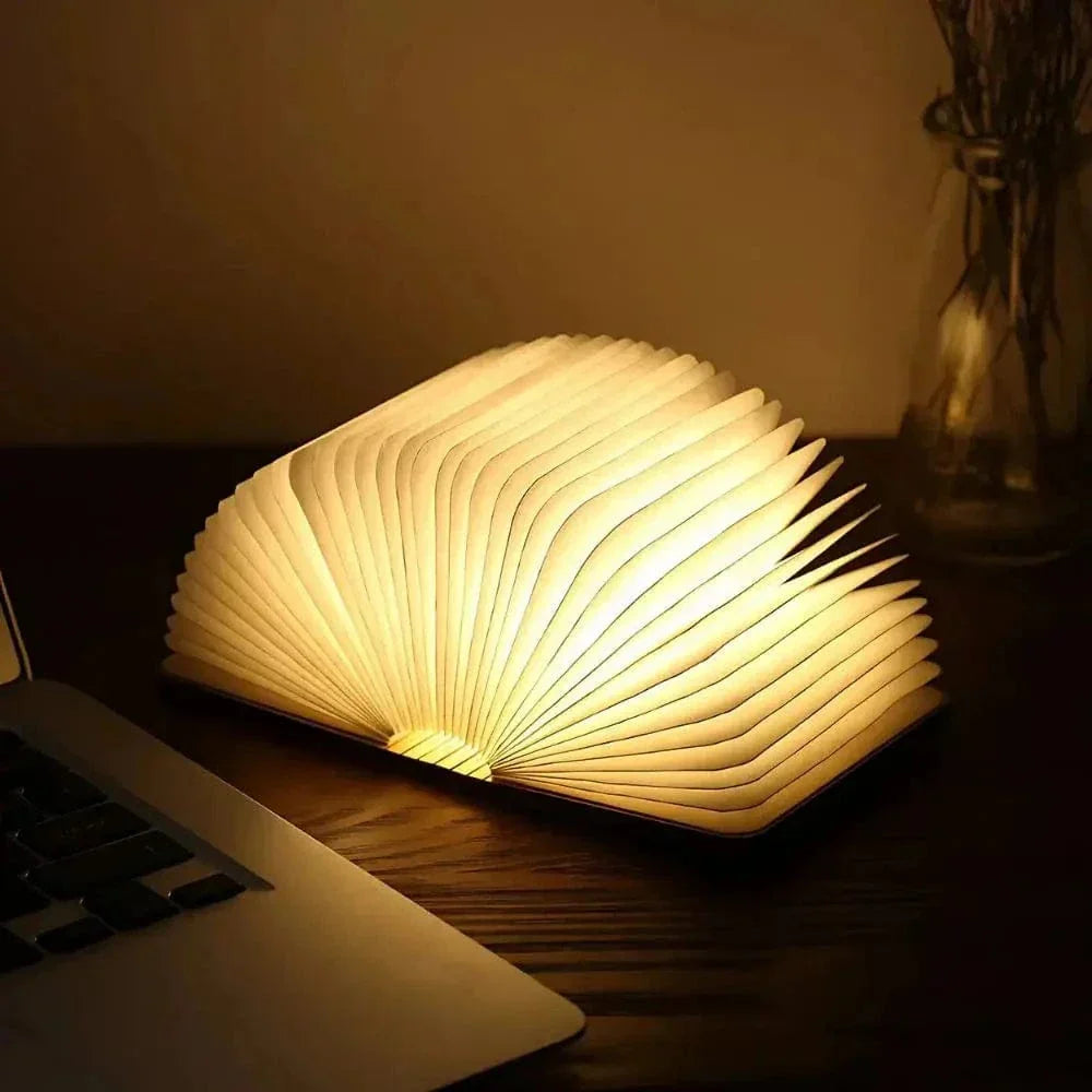 "Elegant foldable LED book lamp, warm white light, 360-degree design, portable for home or travel, wood and paper material."