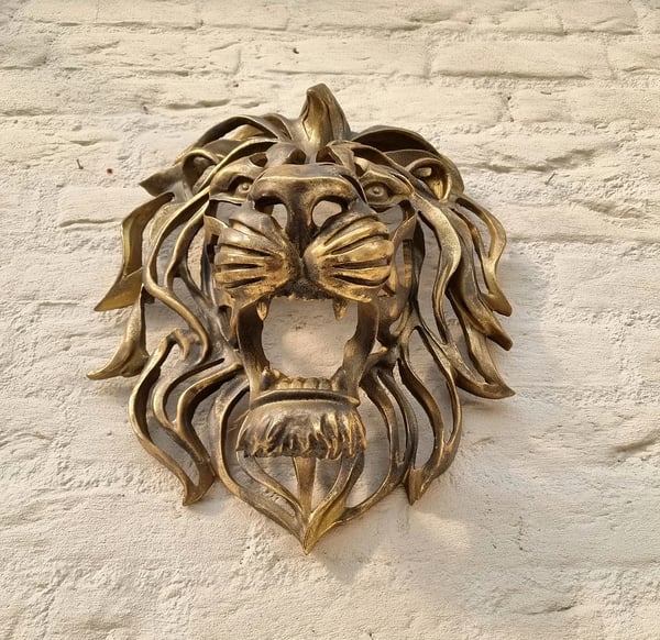 Majestic metal lion head wall decor, an elegant indoor/outdoor art sculpture for a grand home.
