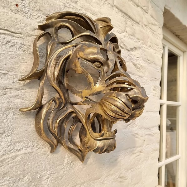 Detailed metal lion head art, an elegant and strong wall decor piece for home or garden display.