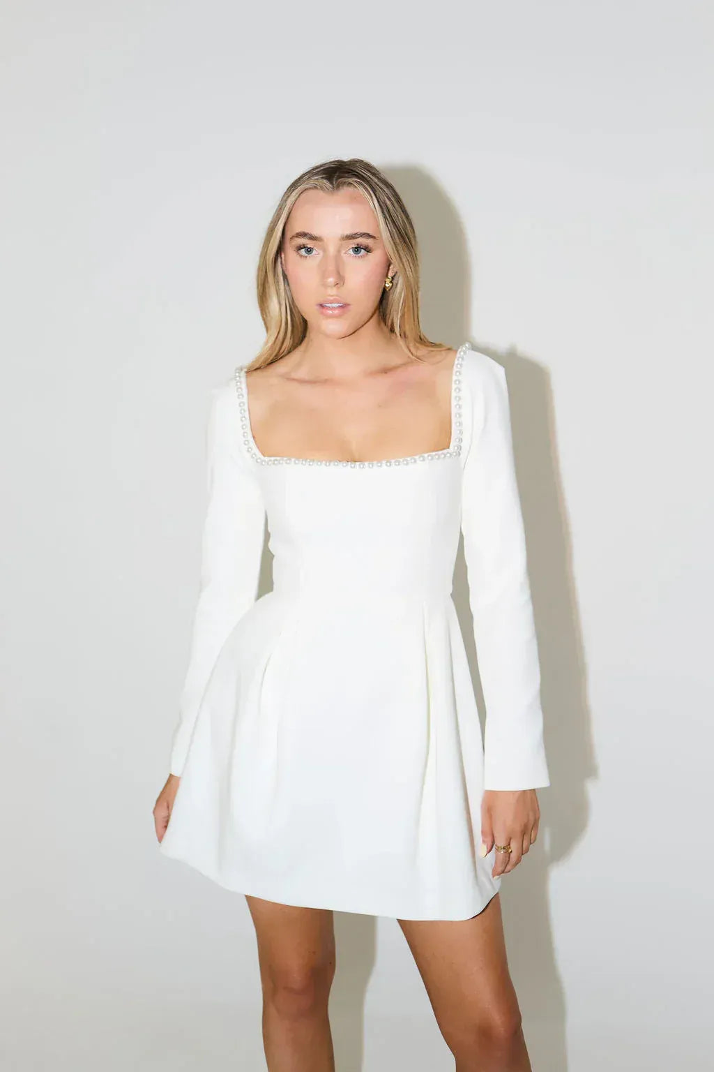 Stunning women's mini dress featuring elegant pearl trim, long sleeves & a chic flared skirt.