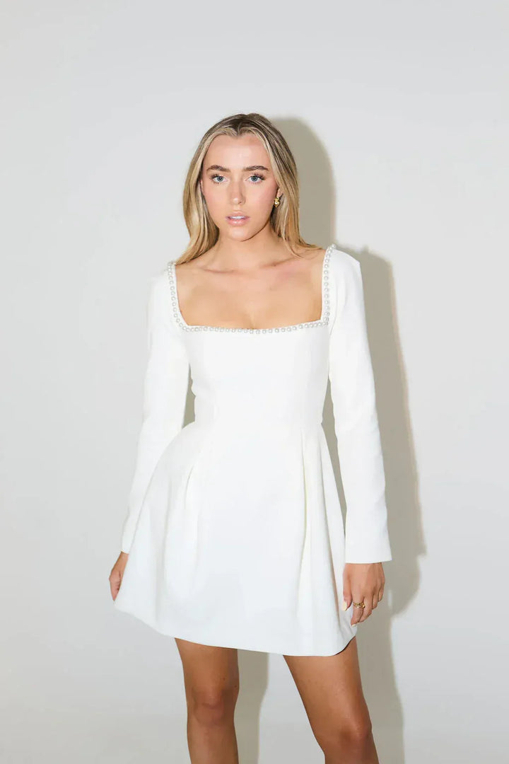 Stunning women's mini dress featuring elegant pearl trim, long sleeves & a chic flared skirt.