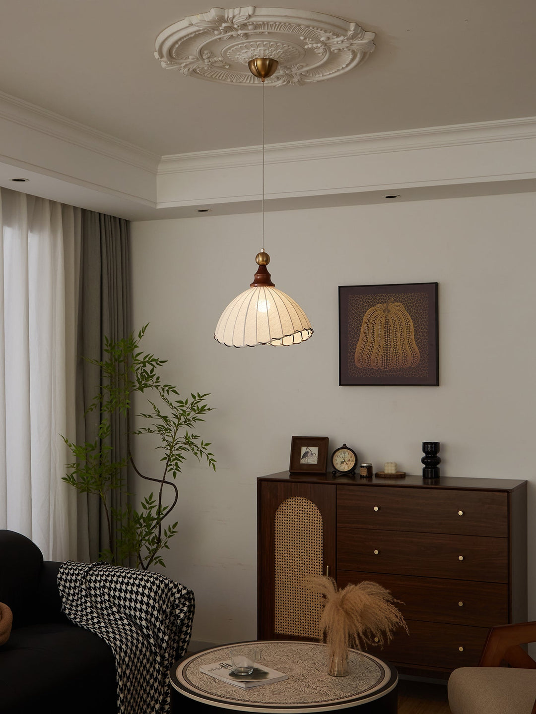 Elegant pendant light with pleated fabric shade, gold-finished top, and wood accent; perfect for modern interiors.