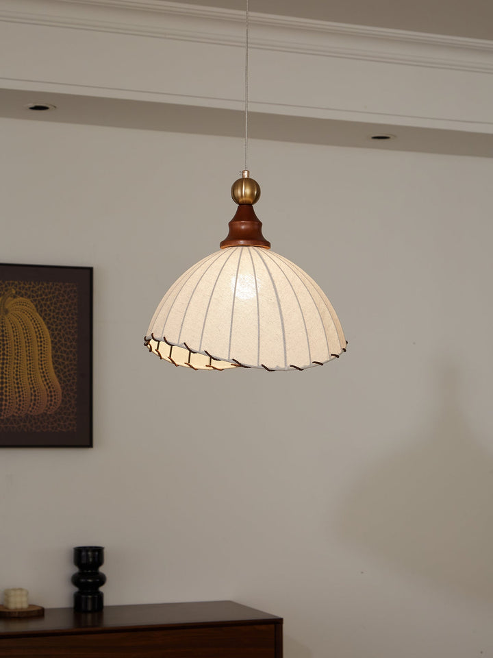 Elegant pendant light with pleated fabric shade, gold-finished top, and wood accent; perfect for modern interiors.