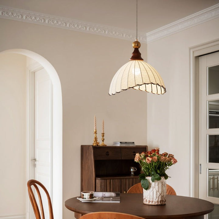 Elegant pendant light with pleated fabric shade, gold-finished top, and wood accent; perfect for modern interiors.
