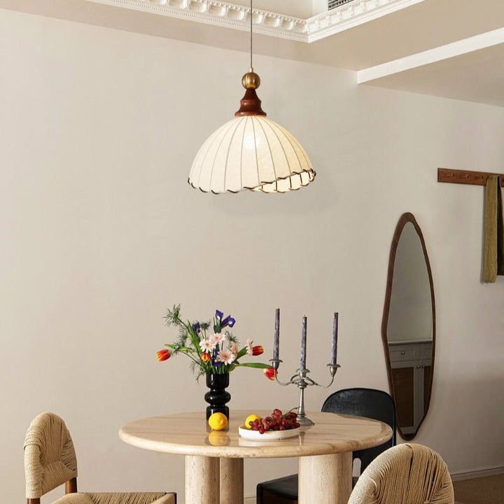 Elegant pendant light with pleated fabric shade, gold-finished top, and wood accent; perfect for modern interiors.