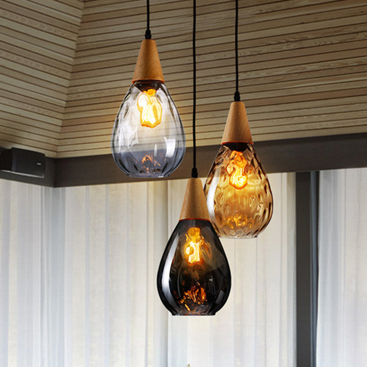 "Elegant teardrop glass pendant light with wood accents, available in clear, golden, smoky gray, perfect for any home decor."