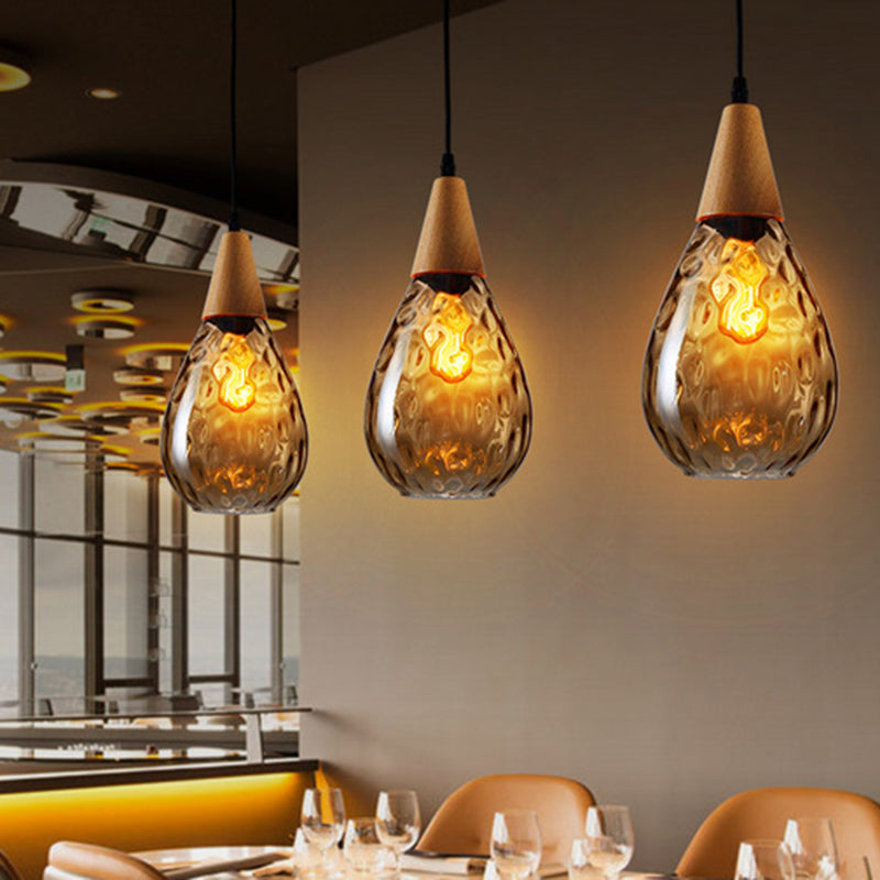 "Elegant teardrop glass pendant light with wood accents, available in clear, golden, smoky gray, perfect for any home decor."