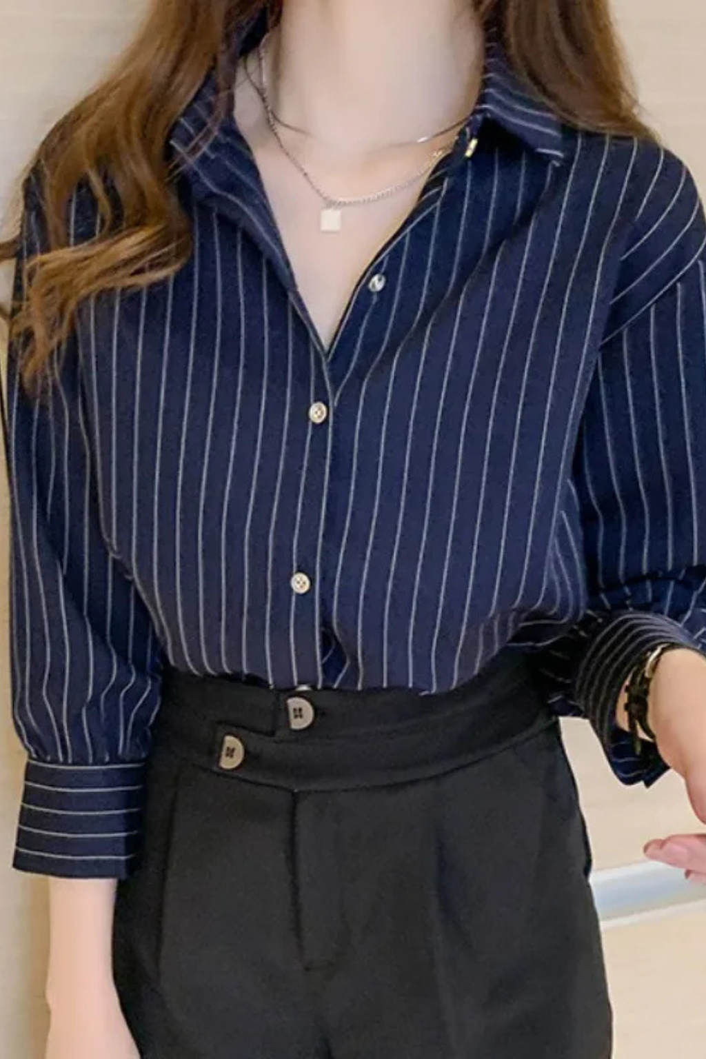 Classic women's white striped button-down shirt with long sleeves & turn-down collar, versatile for work or casual.