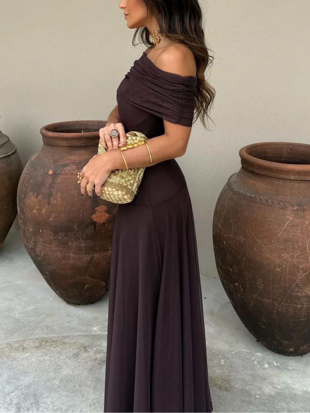 Stylish women's brown off-shoulder maxi dress, showcasing a graceful flowing silhouette for wedding guests.