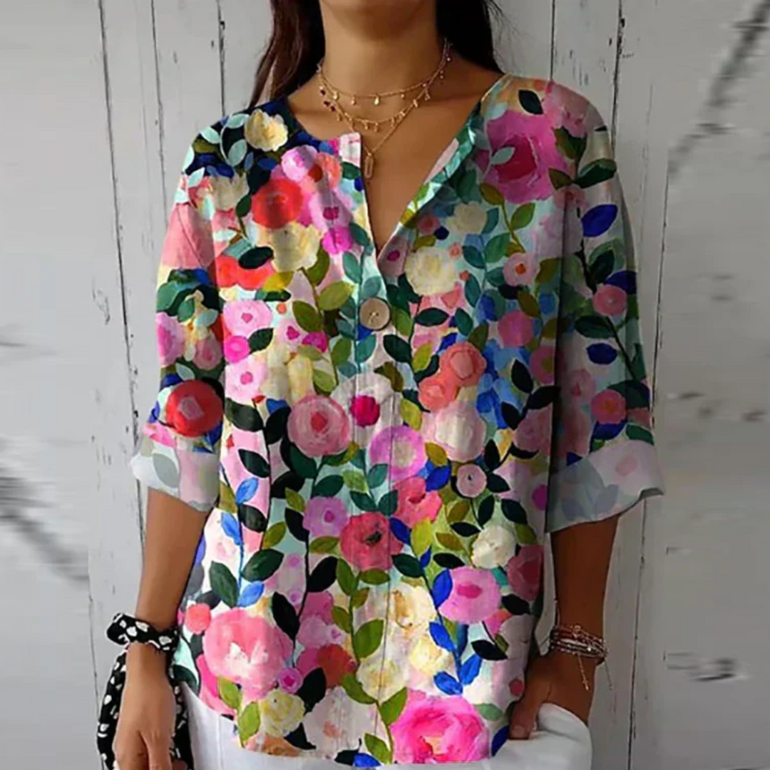 Vibrant floral print women's blouse with 3/4 sleeves and button-down front, a stylish ladies' top.