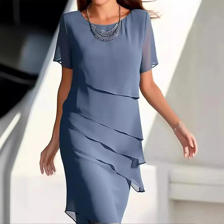 Chic women's flowy midi dress featuring a round neck & short sleeves. Elegant and comfortable for any occasion.