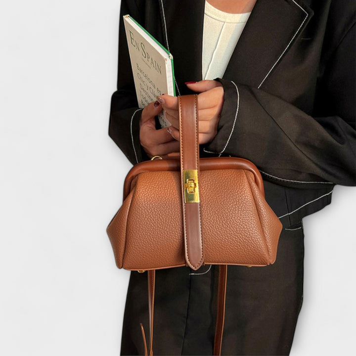 Stylish black leather mini shoulder bag for women, featuring a prominent, elegant turn lock closure.