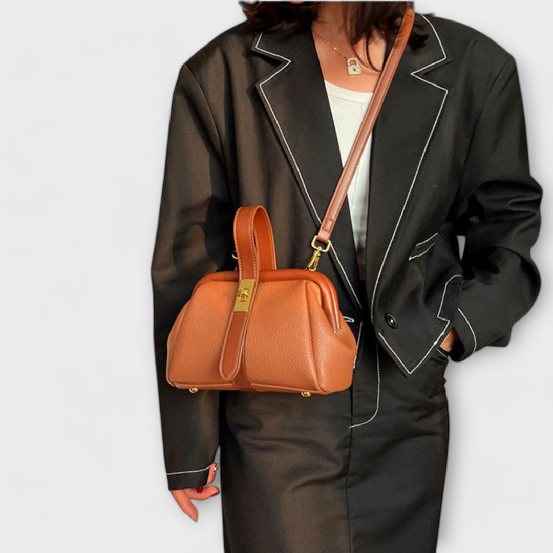 Ladies' fashion accessory: a chic leather mini crossbody bag with a sophisticated gold turn lock.
